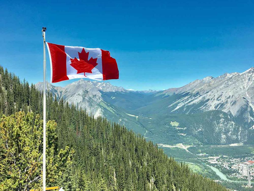 canada-flag-with-mountain-range-view-756790.jpg